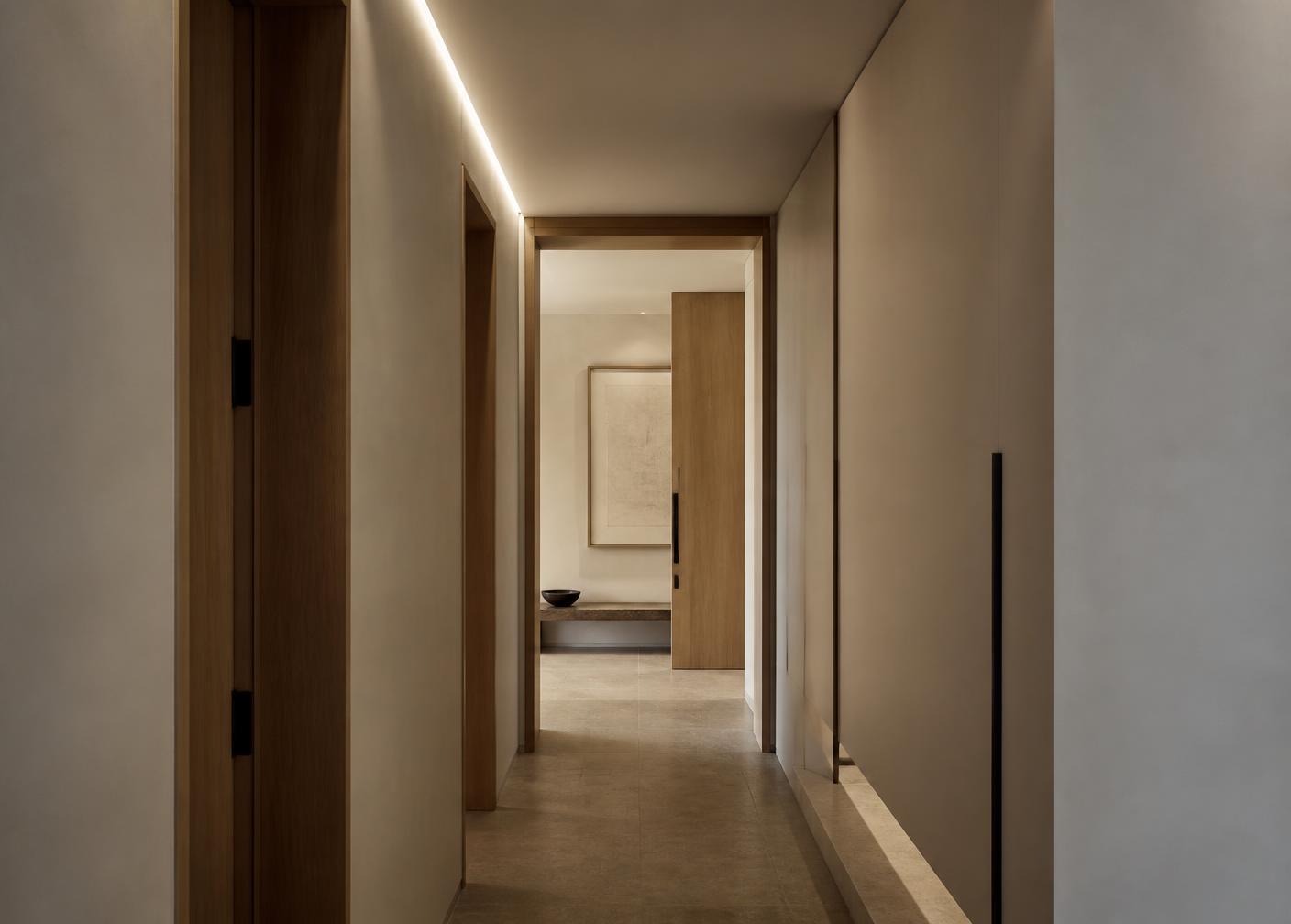 Pasillo con muros de pasta y luz lineal integrada